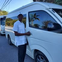 A Byron’s Jamaica Tours driver beside a passenger van